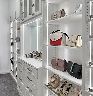 Custom walk in closet with LED lighting strips and purse display Closet Factory DFW