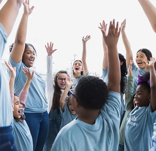 A diverse group of enthusiastic volunteers, including children and adults