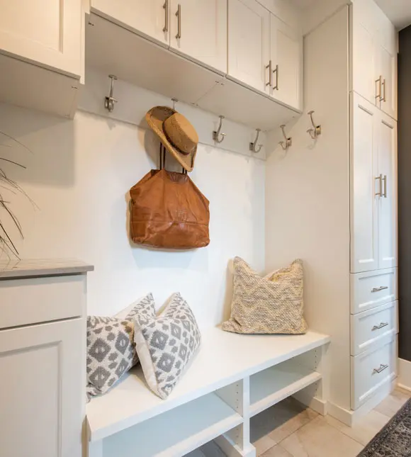 Built-in mudroom bench with overhead hooks, tall storage cabinets, and open cubbies.