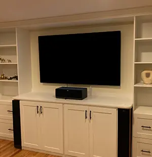 Built in entertainment center cabinetry around TV in shaker white