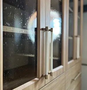 Glass front cabinets with gold and white hardware