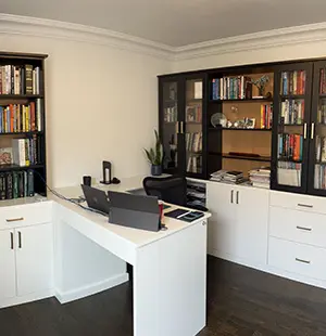 Modern home office with an L-shaped white desk, dual monitors