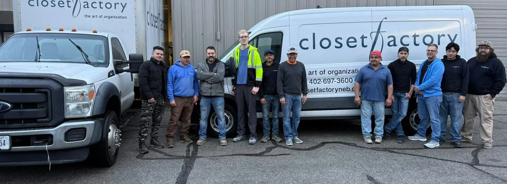 Group of closet shop workers posing for a photo in front of the shop