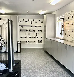 Spacious garage or home gym with sleek wall-mounted storage panels, built-in cabinets, and organized equipment zones
