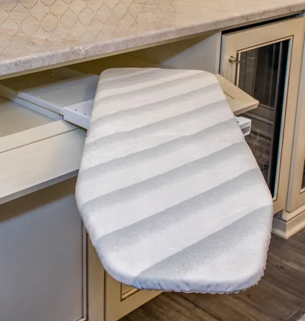 Pull-out ironing board stored inside a cabinet.