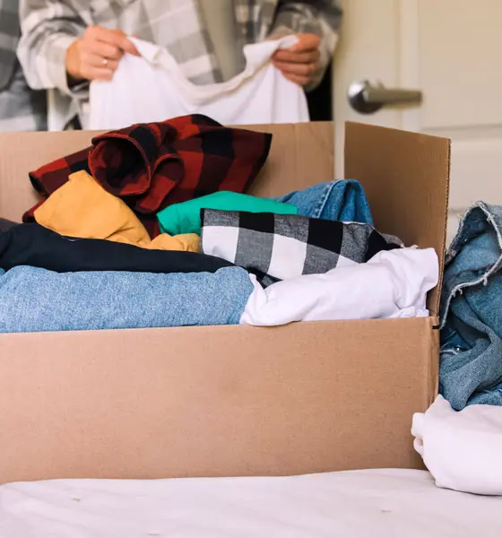 a person setting clothes inside a box