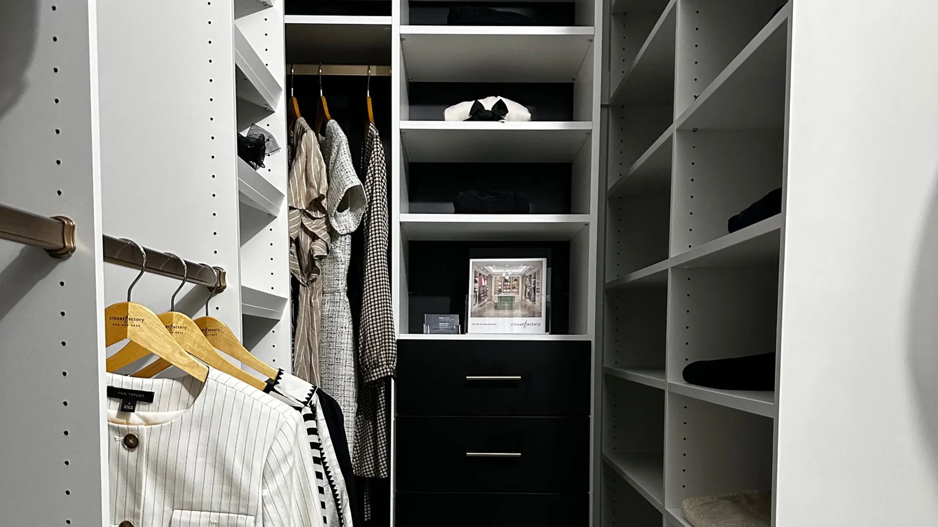 preview of white custom built walk in closet with a closet factory brochure in view
