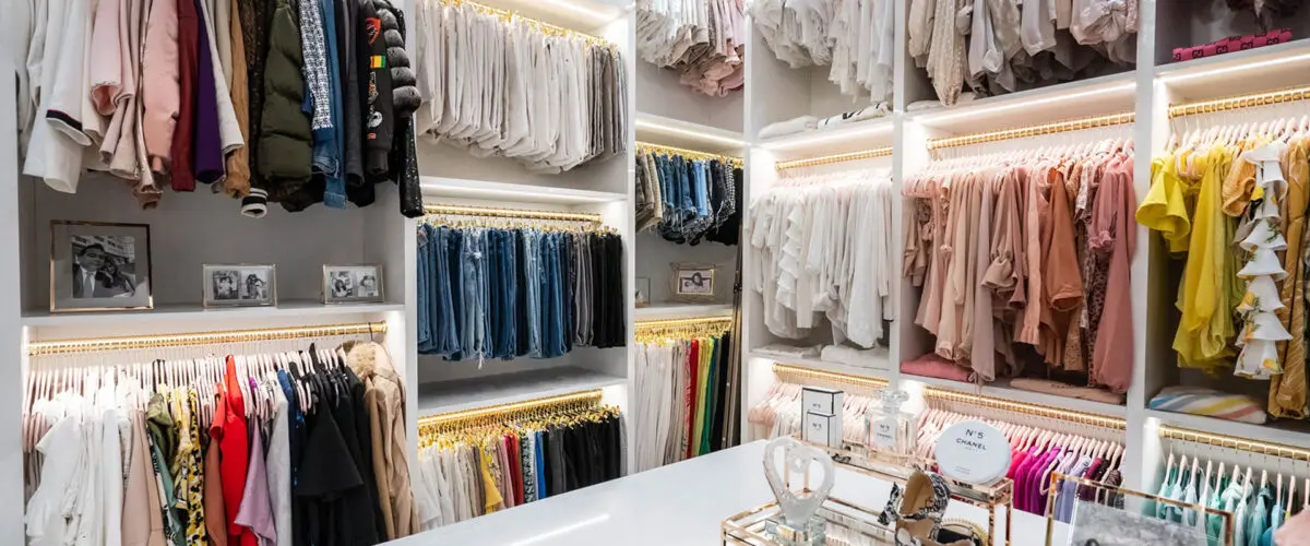 walk-in closet with triple hanging and island