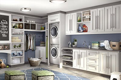 Laundry room has cabinets on two walls designed around stackable washer/dryer system.