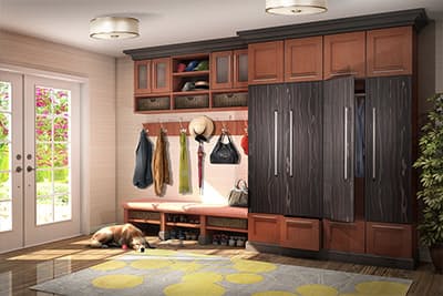 Entry mudroom style bench is custom made withtall hanging cabinets to the right for coats and storage.