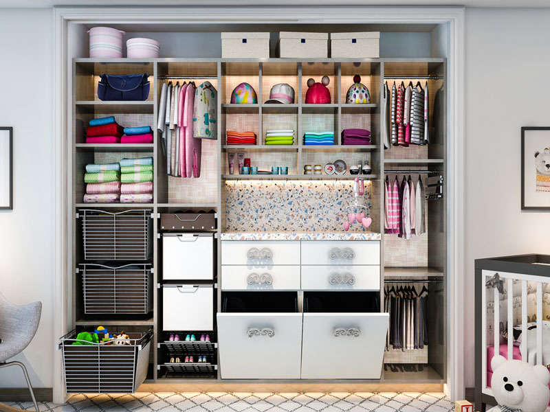 Baby nursery bedroom reach-in custom closet is well organized with clothing, toys and baby built-in changing table with mobile above.