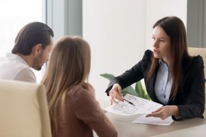 closet designer from closet factory shows elevations to a couple at a table.