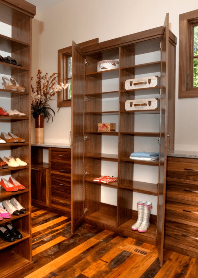 A cabinet with doors storing a few items in a walk-in closet