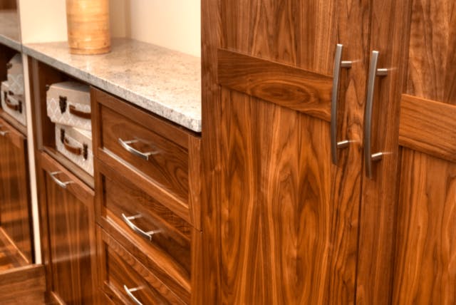 Stained wood cabinetry with stainless fixtures