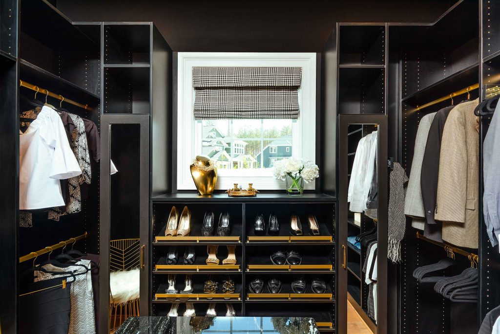 close up of a black closet with brass shoe stops