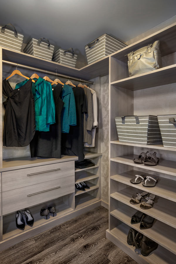 A light wood closet with clothes and shoes