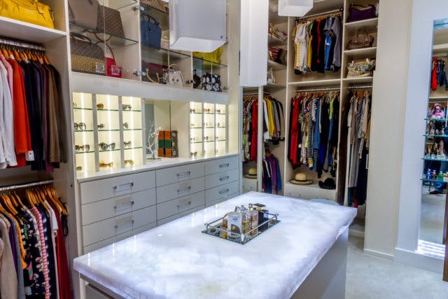 A large walk-in closet with boutique style displays for sunglasses