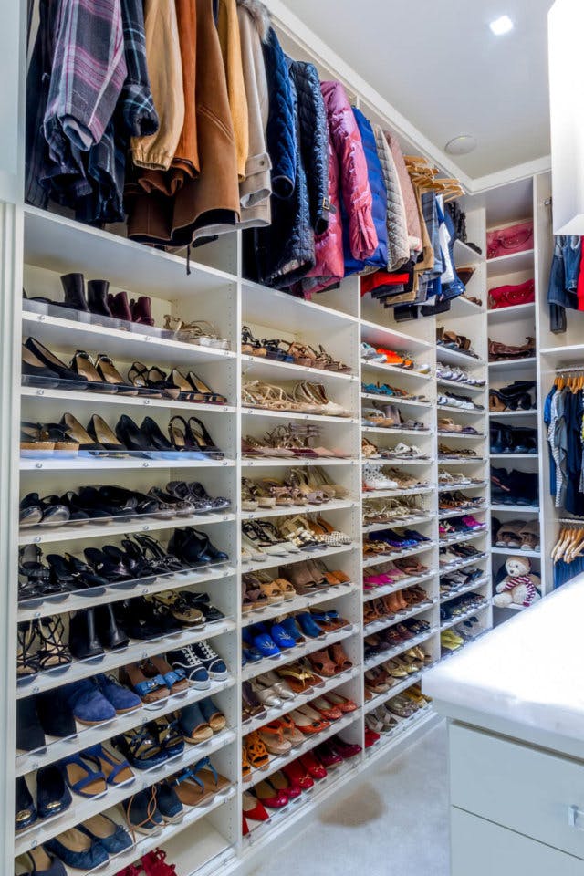 A shoe closet with some hanging space up above