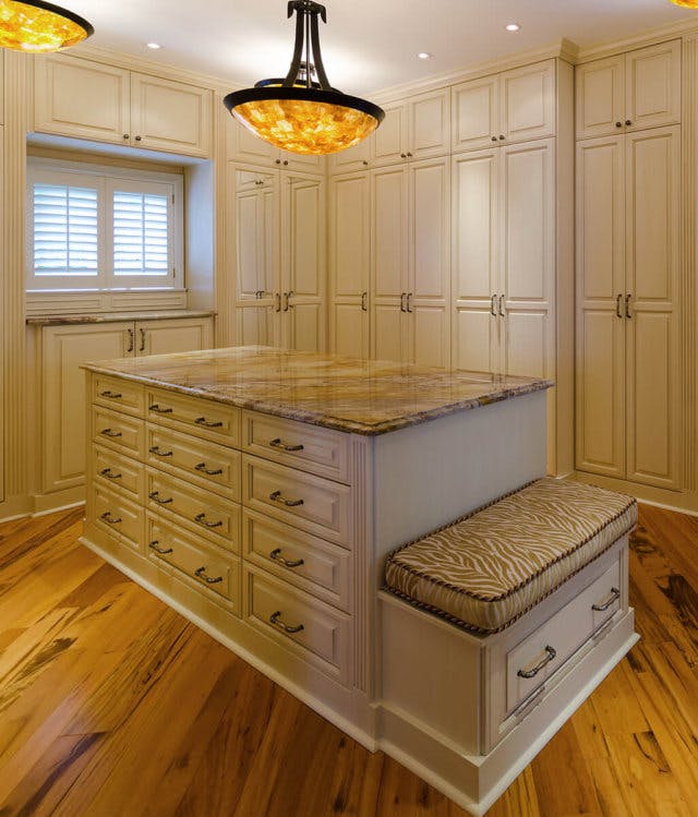 A large walk-in closet with a large central island