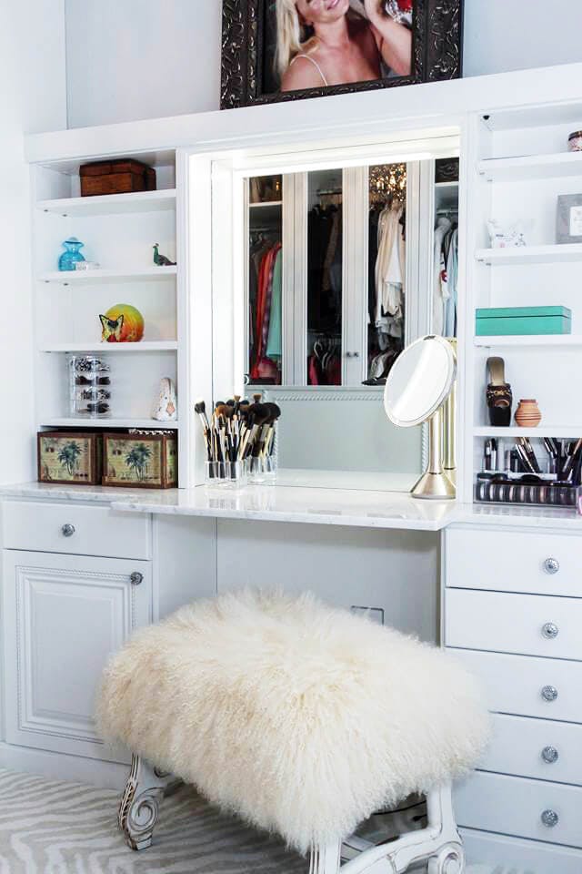 A seating area in front of a countertop for doing makeup