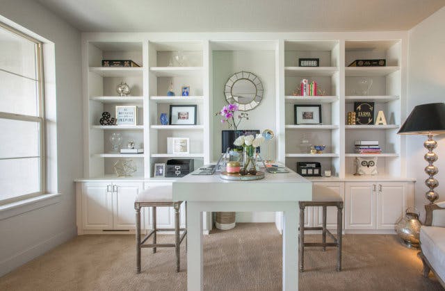 A white office with a long tall table 