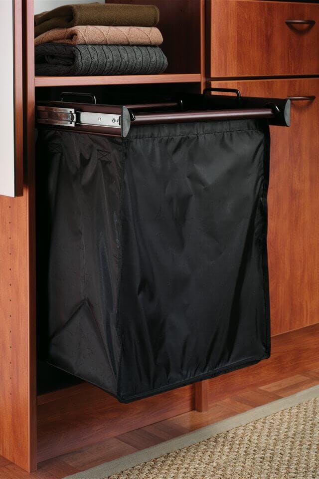 A hamper on extending arms protrudes from a stained wood closet