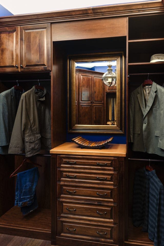 A perfect man's closet, with dark wood, shaker doors, and lots of jacket storage