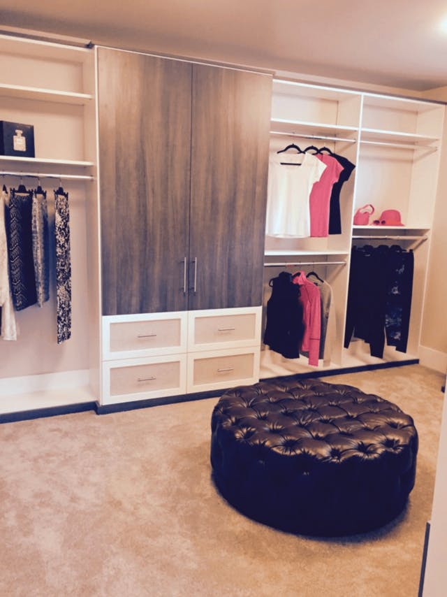 White walk-in closet with two tiered hanging and wood grain accents