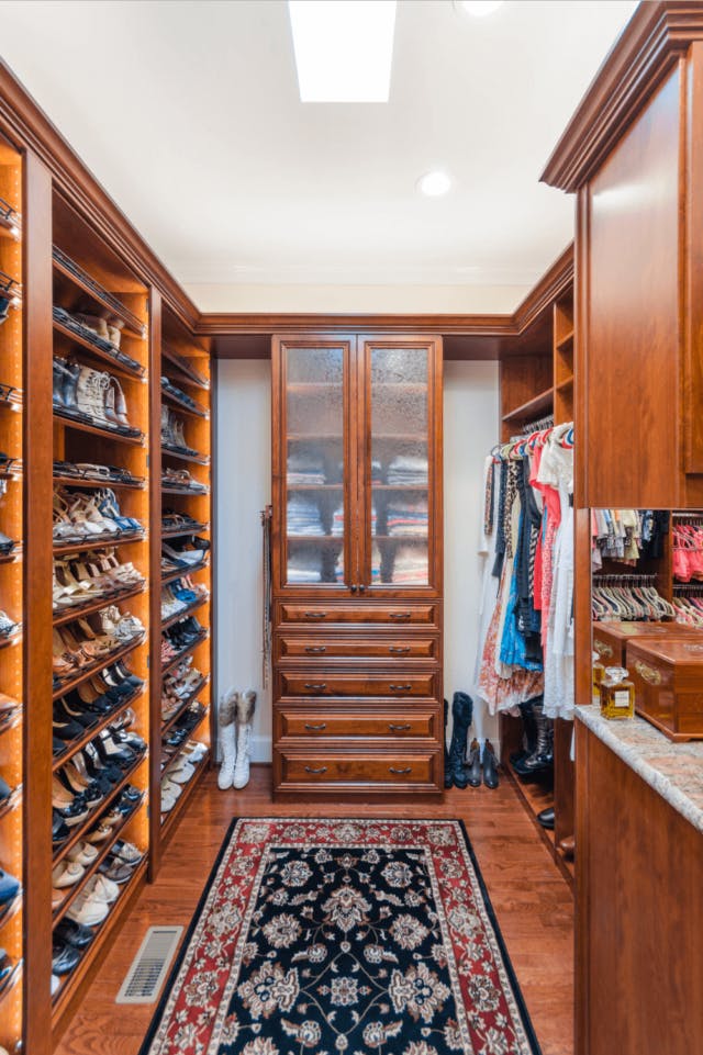 A walk-in closet with a large shoe section