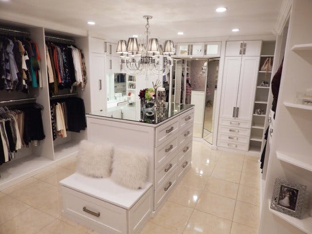 A white walk-in with marble floor and island