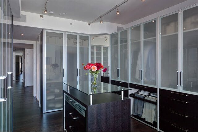 A closet with frosted glass doors at the end of a long hall