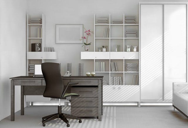 A two-tone office. Shelves and walls are white, while desk and office chair are dark brown