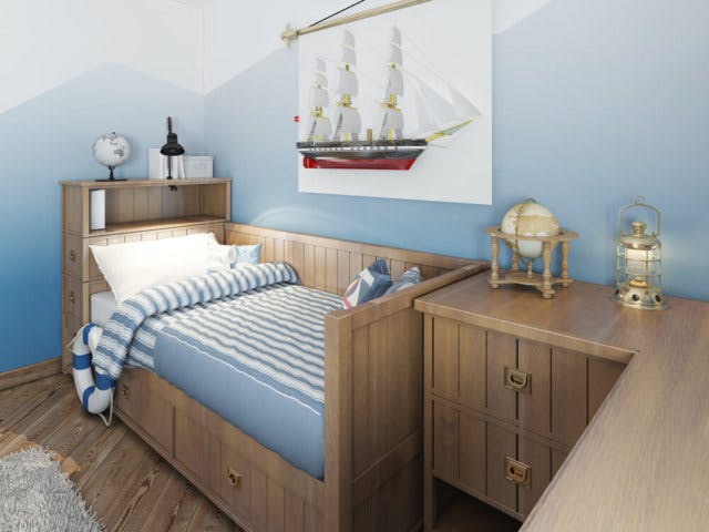 A daybed with blue and white stripes. There is a matching corner cabinet and a model ship on the wall
