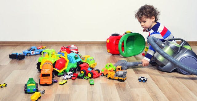 A toddler surrounded by toy cars