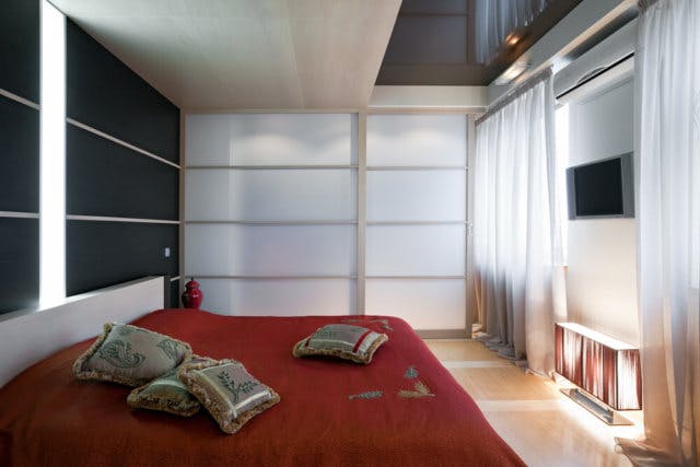 A large red bed in a bedroom