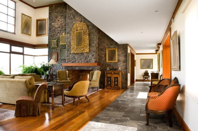 A large great room with a fireplace and lots of seating. One wall is covered in mirrors