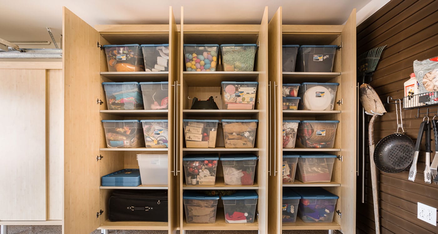 garage cabinets open with plastic bins for holiday storage