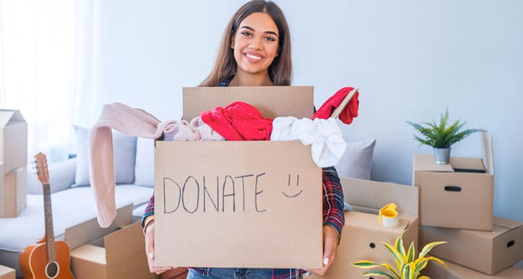 woman holding box of clothing for donation