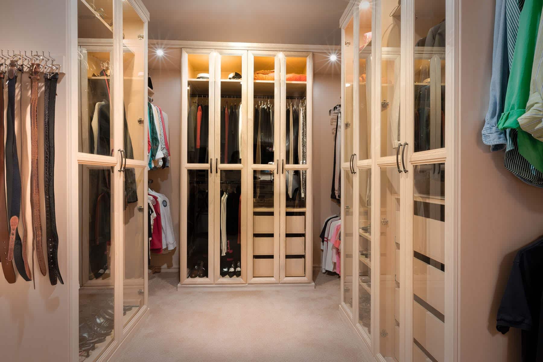 Amazing walk-in closet built-in cabinets with custom lighting showcasing  designer bags finished with glass-f…