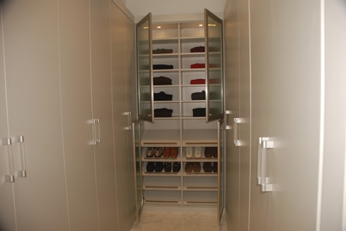 The end of a hallway with a shoe closet
