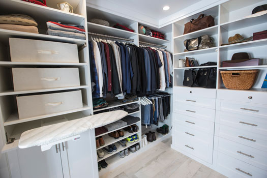 closet with built-in ironing board in drawer