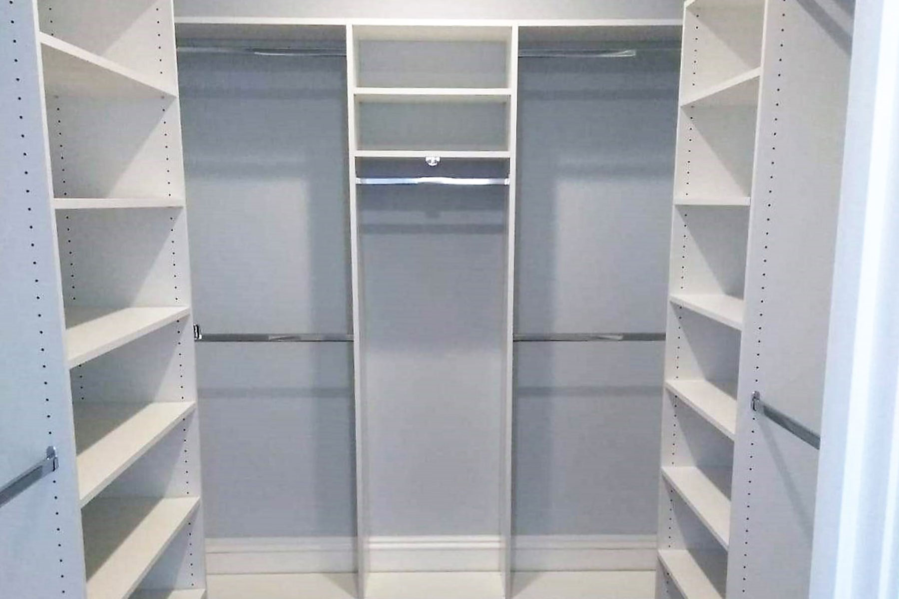 white walk in closet with hanging sections