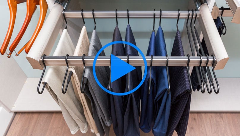 pants being hung on a pant rack in a closet