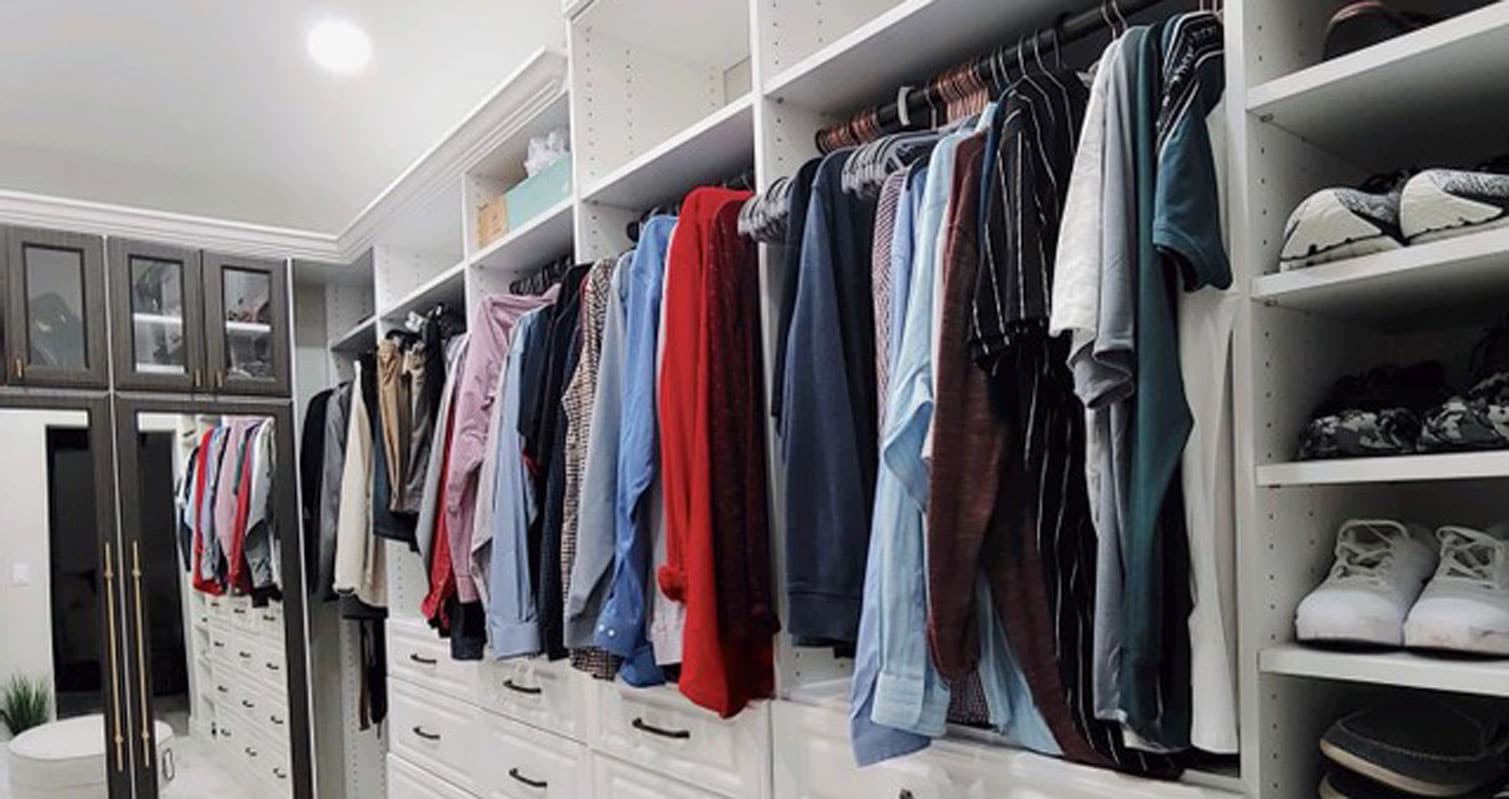 organized clothing in a custom white closet