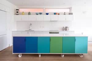 A brightly colored kitchen island on wheels