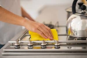 A person cleans their range-top 