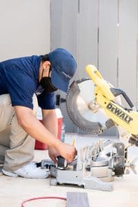 A workman cutting a board