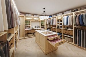 A walk-in closet with an island and chandelier lighting