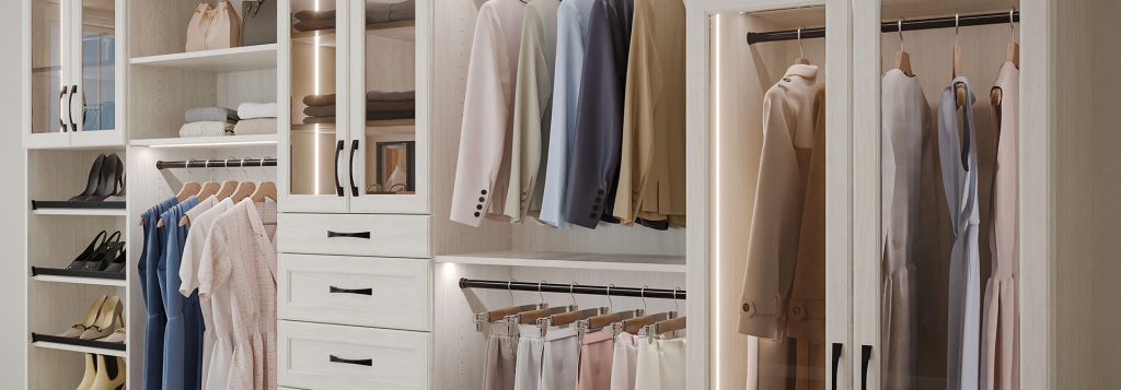 Elegant walk-in closet featuring light wood cabinetry with glass-front doors, built-in drawers, and illuminated hanging rods. Clothes, shoes, and accessories