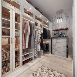Boutique-style closet with marble-finished Raised Panel doors, LED-lit shelves, and glass drawer fronts.